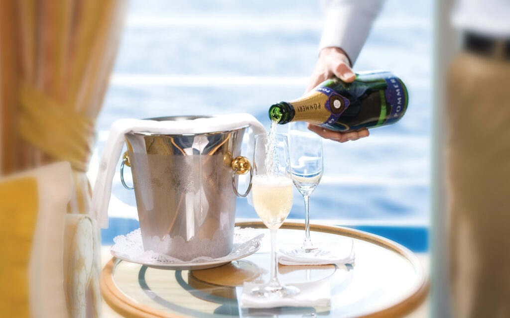 Champagne hældes op i suite med havudsigt som en del af all inclusive-luksus